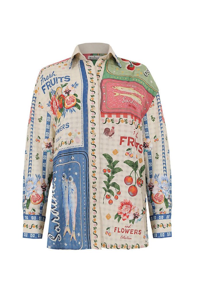 Long-sleeved button-up shirt with vintage-inspired print featuring sardine tins, fruits, flowers, and text panels on cream background