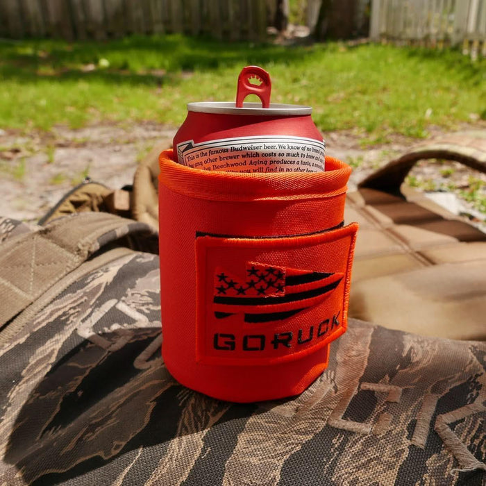 GORUCK orange beer can koozie outdoors on backpack with American flag patch logo