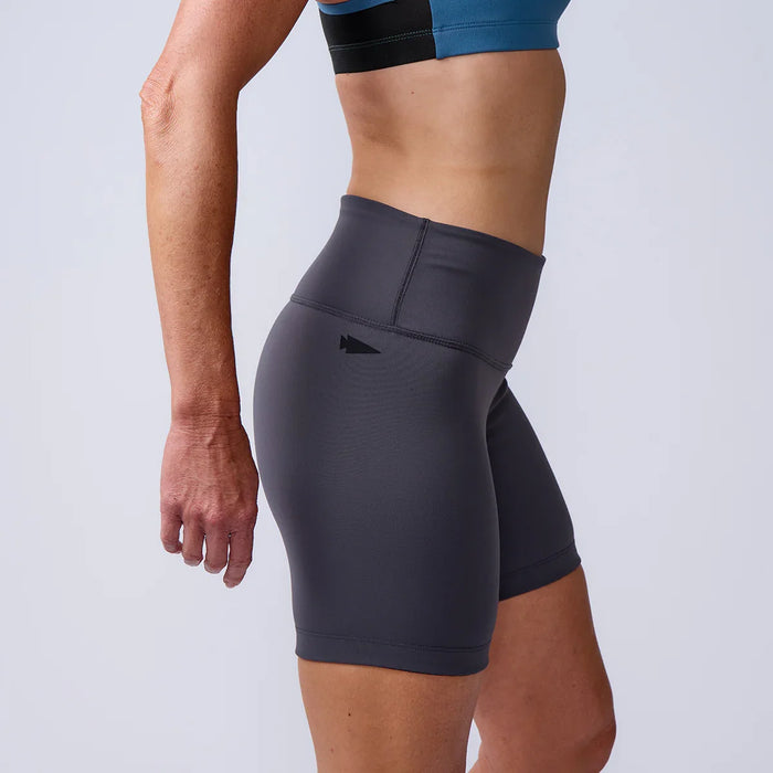Woman wearing GORUCK high-waisted athletic shorts in gray, side view studio shot