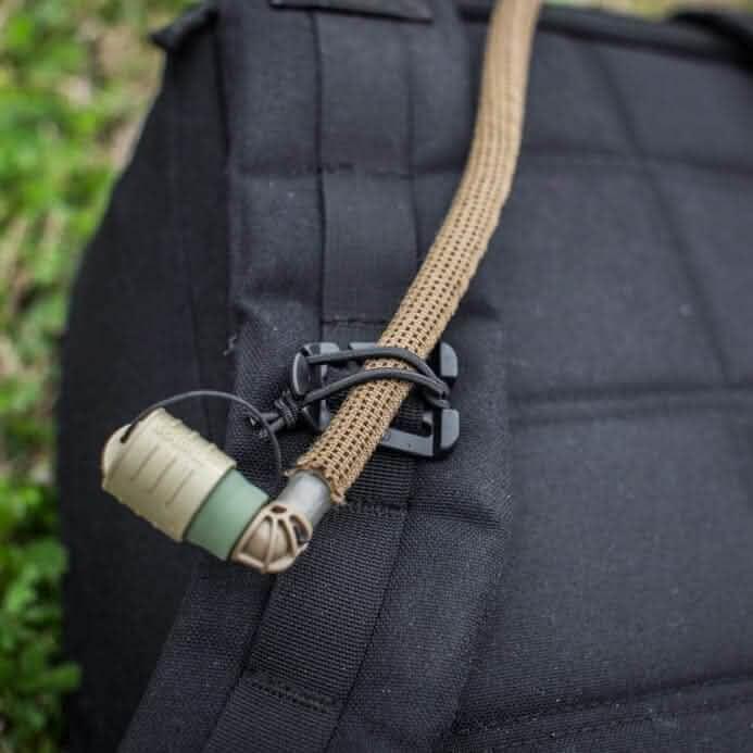 GORUCK black rucksack with Web Dominator securing tan strap and hydration tube outdoors