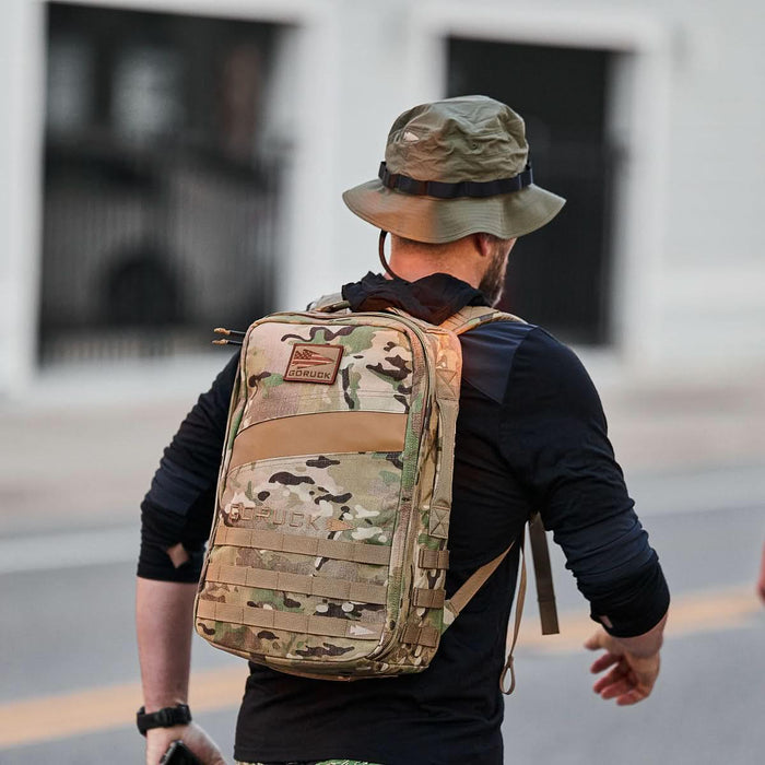 Man wearing GORUCK Ranger Green boonie hat and camo rucksack outdoors