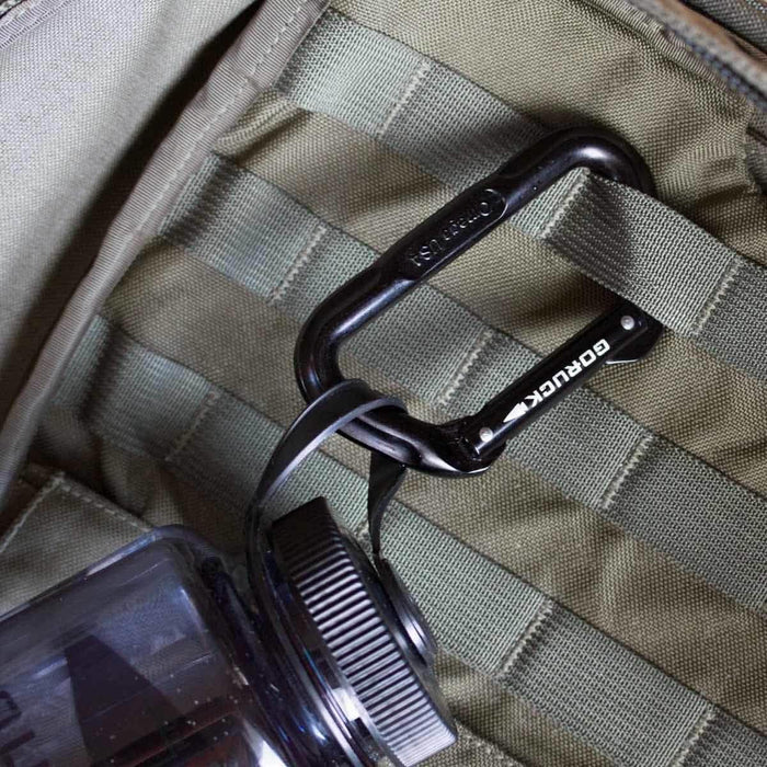 GORUCK black carabiner attached to MOLLE webbing inside tactical backpack