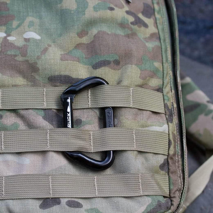 Black Omega Pacific non-locking carabiner clipped to a camouflage GORUCK rucksack
