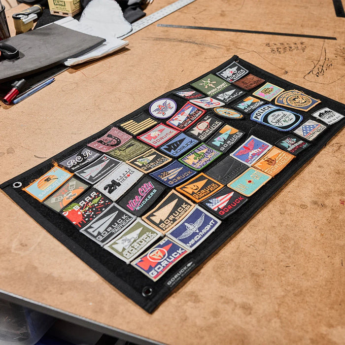 GORUCK patch board with assorted ruck patches on a workshop table