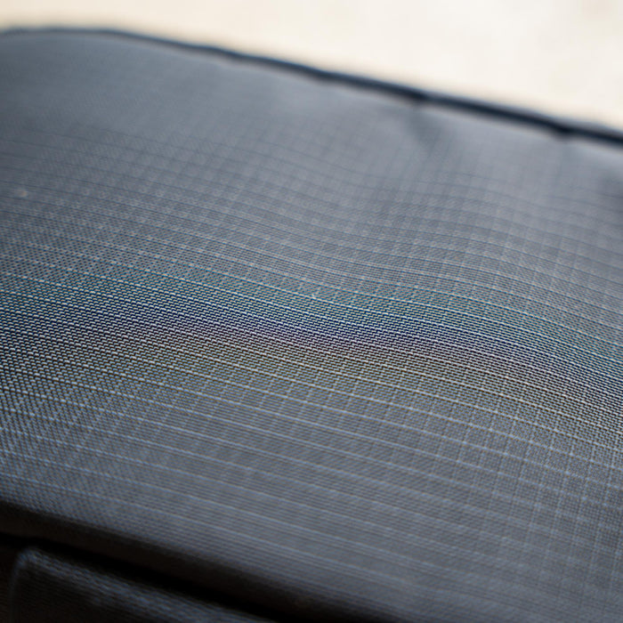Close-up of IFAK (Black + Red Thread + Grey Interior + Red Patch) ROBIC w/ Aquaguard fabric featuring textured dark gray surface, faint grid lines, and a subtle iridescent sheen.