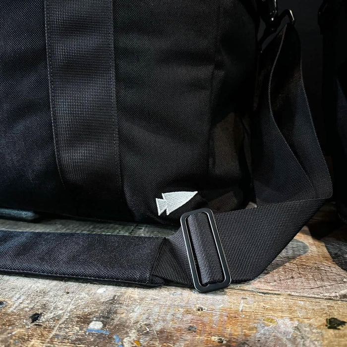 GORUCK black rucking bag shoulder strap detail on rustic wooden surface