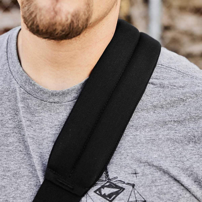 Close-up of man wearing grey GORUCK t-shirt and black ruck sack strap outdoors