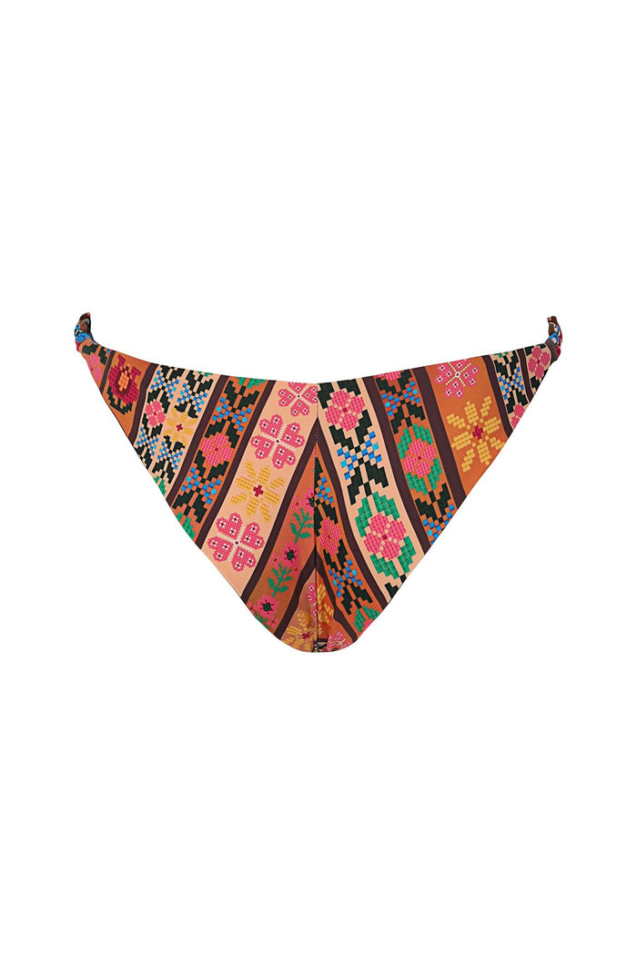 Maisie bikini bottom with tie-side straps, ring details, and vibrant diagonal striped pattern featuring geometric pattern detail shapes in pink, oran…