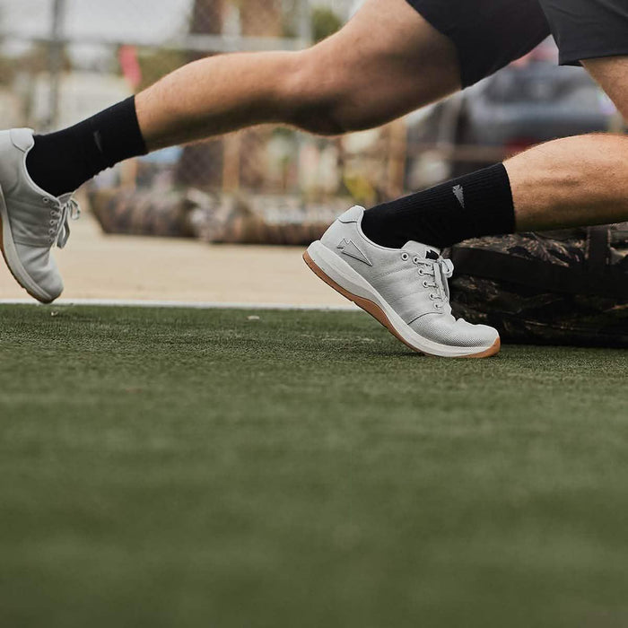 GORUCK white rucking shoes on athlete sprinting outdoors on artificial turf