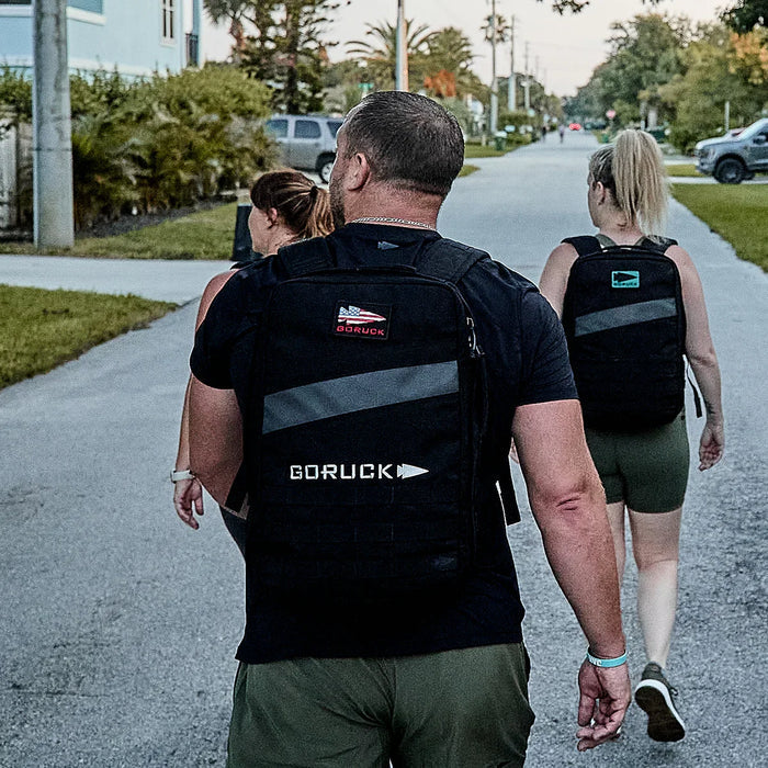 People rucking outdoors wearing GORUCK backpacks on a suburban street