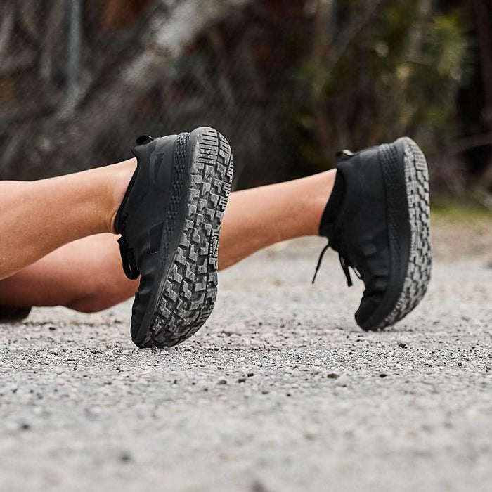 GORUCK black rucking shoes with rugged soles on gravel, outdoors close-up