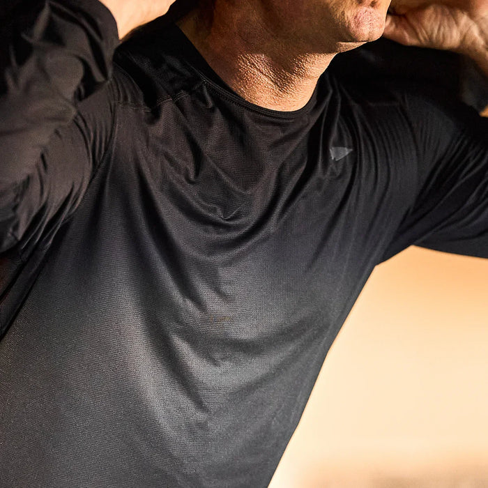 GORUCK black long sleeve performance tee shirt worn by man indoors, close-up view