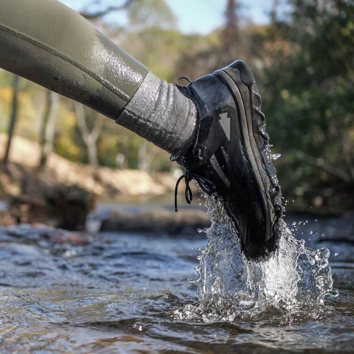 GORUCK rucking shoe and grey sock splashing in outdoor stream, rugged trail gear