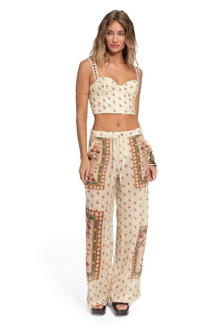 Cream crop top with rust dot pattern and pattern detail bordered straps, paired with matching wide-leg pants featuring decorative panel details