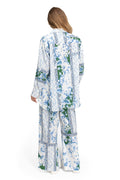 White wide-leg pants with vertical blue pattern detail stripe print and green accents, back view showing matching long-sleeve top