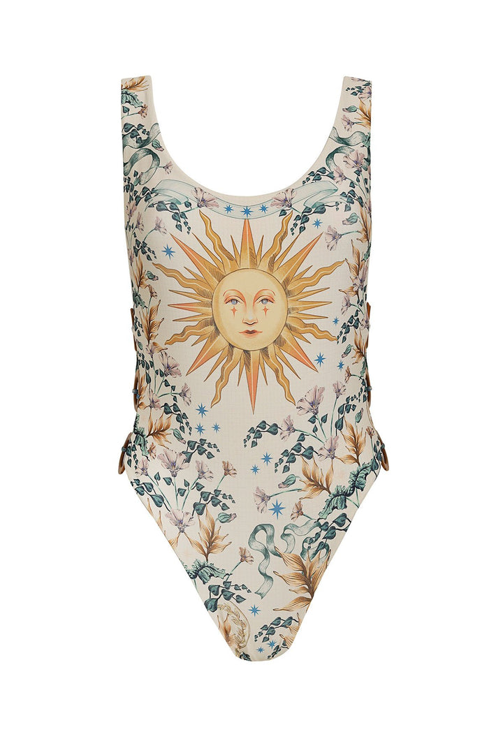 Yara one piece swimsuit in cream with botanical print featuring a central sun face, pattern detail vines, and blue stars, with cut-out sides and ring…