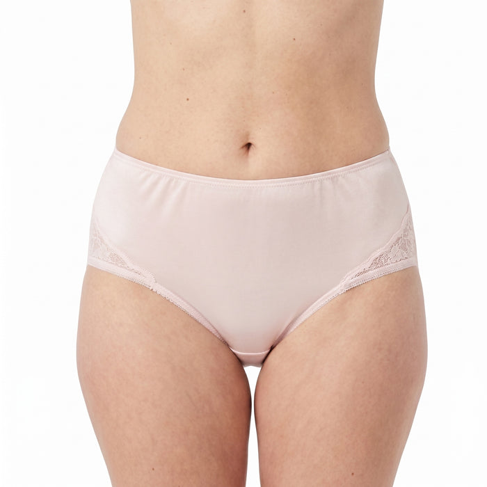 A person models Teri Lingerie’s NYLON GUSSET Nylon and Lace Brief Panty (Style M108/Beatrice) 3 Pack in Assorted, featuring high-waisted, light pink full coverage with lace side detailing against a white background.