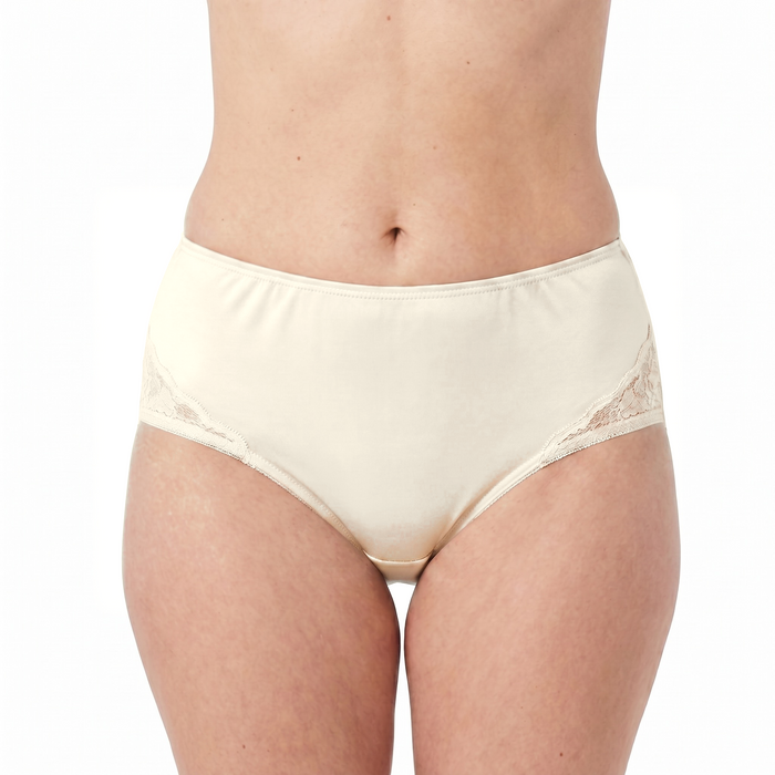 A person models Teri Lingerie’s M108 Beatrice nylon and lace brief in Ivory, featuring a high-waisted full-coverage fit, lace side detailing, and a sewn-in 100% cotton liner; sold as a solid Ivory 3-pack.