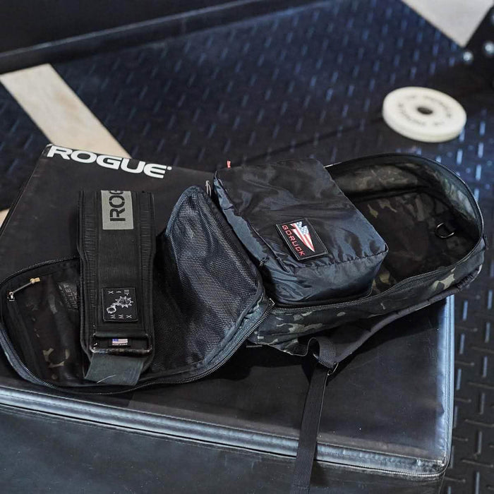 GORUCK black gym packing cube inside open rucksack on gym bench, fitness gear visible