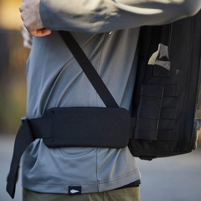GORUCK padded hip belt on backpack, worn by person in gray shirt outdoors
