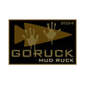 GORUCK Mud Ruck 2024 patch with tan arrow and muddy handprints on black background