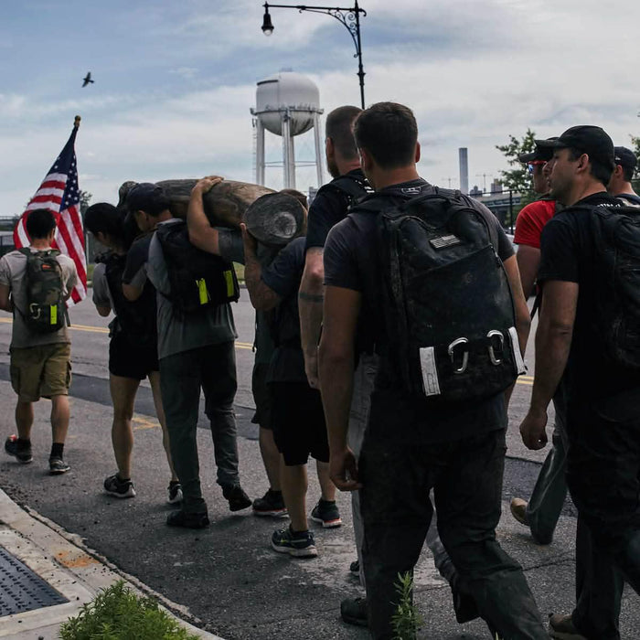 GORUCK team carrying a log and American flag during outdoor rucking event