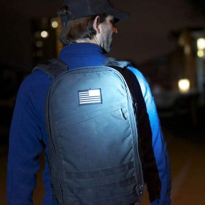 GORUCK black rucksack with embroidered reverse flag patch worn outdoors at night