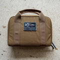 The brown Pistol Rug with handles and a "GORUCK Tactical" patch sits on a light textured surface—ideal as a modular pistol case or magazine pouch.