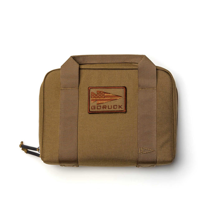 A tan GORUCK Pistol Rug made from rugged 1000D Cordura, featuring sturdy handles and a jet logo patch on the front.