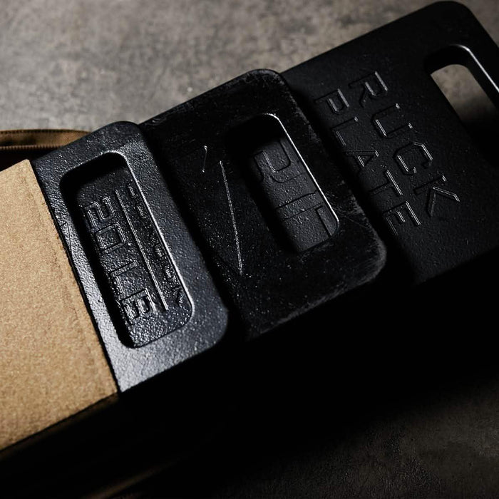 GORUCK ruck plates in a sand-colored rucksack, durable training gear on concrete surface