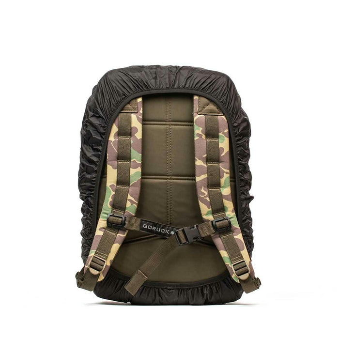 GORUCK camo rucksack with padded straps and black rain cover, rear view