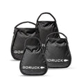 Four black GORUCK Kettlebell Bundle sandbags of different sizes with handles, grouped on a white background—each built tough like portable sand kettlebells and backed by a lifetime guarantee.