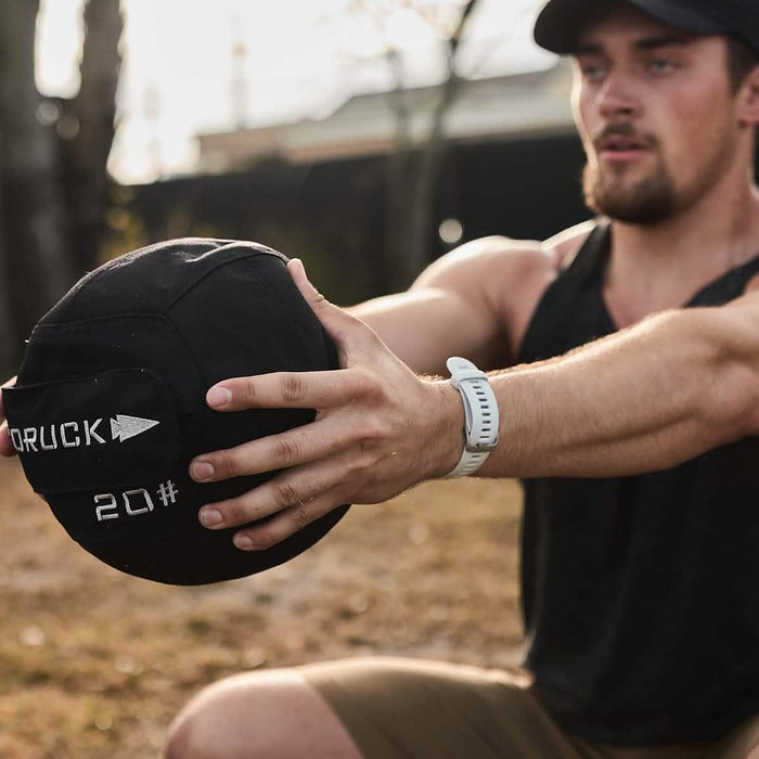 Man training outdoors with GORUCK branded 20 lb ruck weight, fitness and rucking gear
