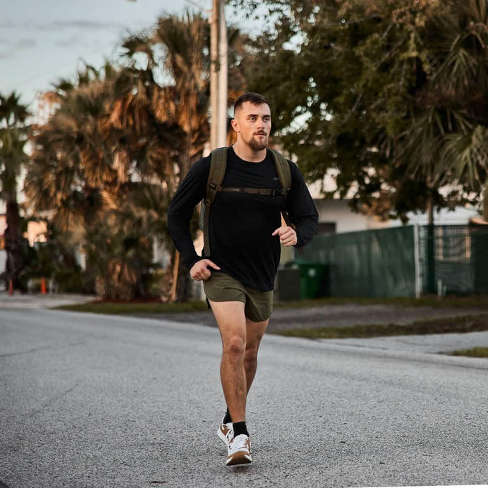 Man rucking outdoors wearing GORUCK Tough Mesh Long Sleeve shirt and backpack on street