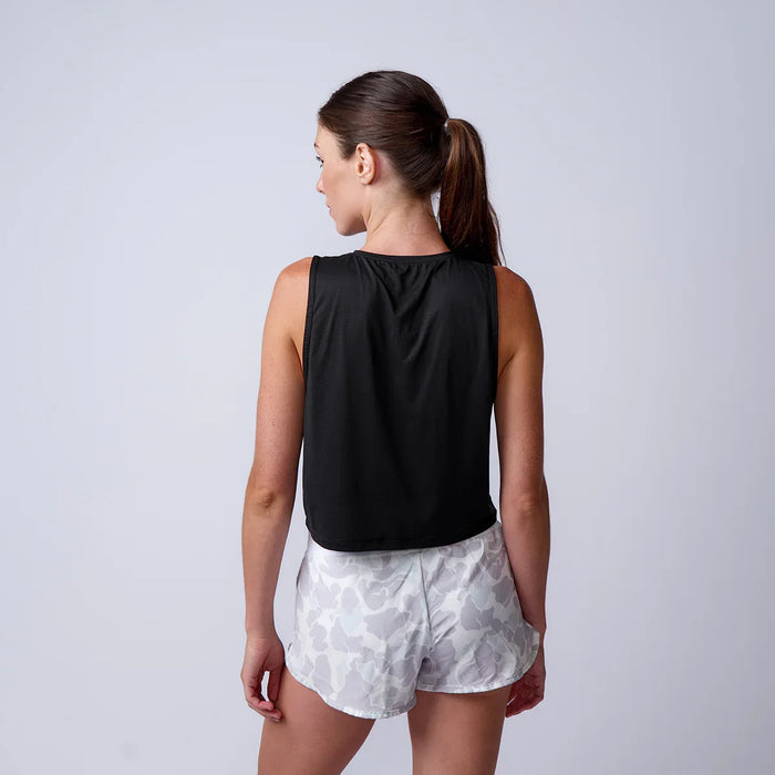 Woman wearing GORUCK black tank top and camo shorts, back view, against a plain background