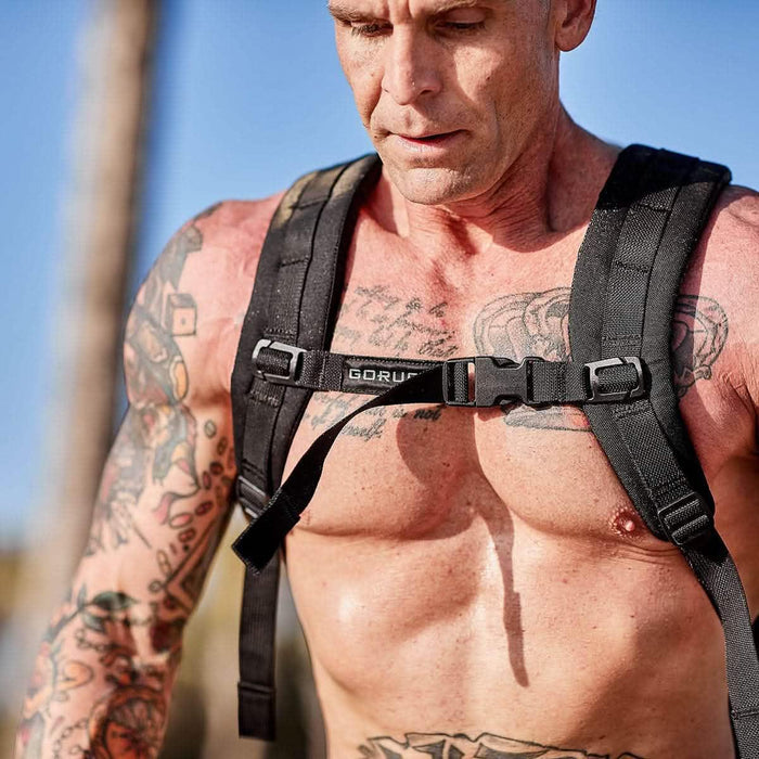 GORUCK black training sternum strap on athletic person with tattoos outdoors