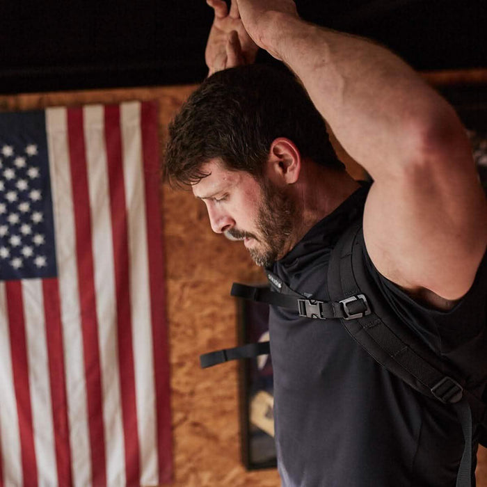 Man wearing GORUCK rucksack with sternum strap, American flag in background