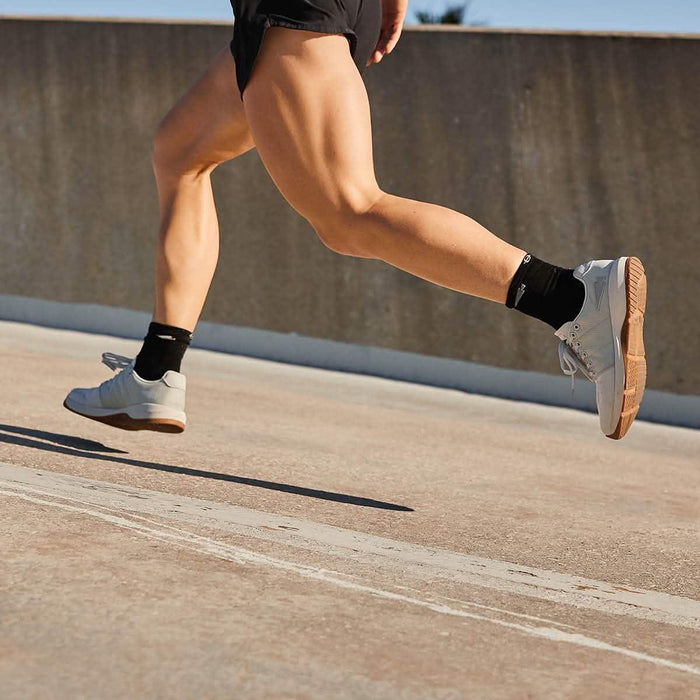 GORUCK athlete running outdoors in white rucking shoes and black socks