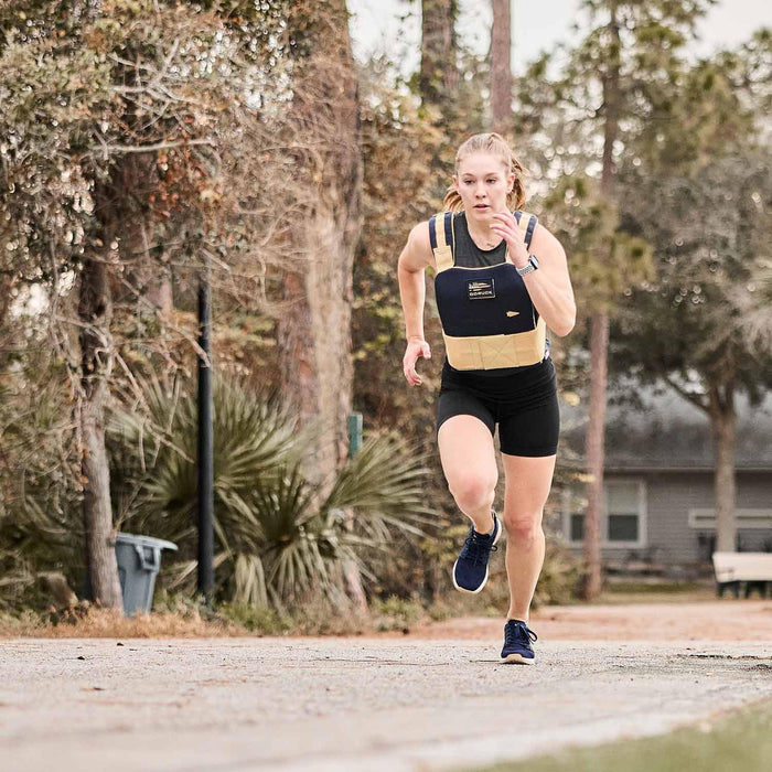 Woman running outdoors in GORUCK weighted vest and shorts during rucking workout