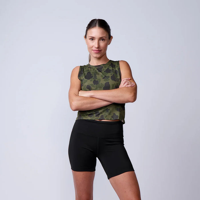 Woman in camo crop tank and black athletic shorts standing with arms crossed, GORUCK gear